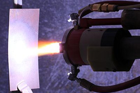 Plasma torch depositing recycled magnet material.