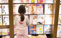 little girl looking at magazines