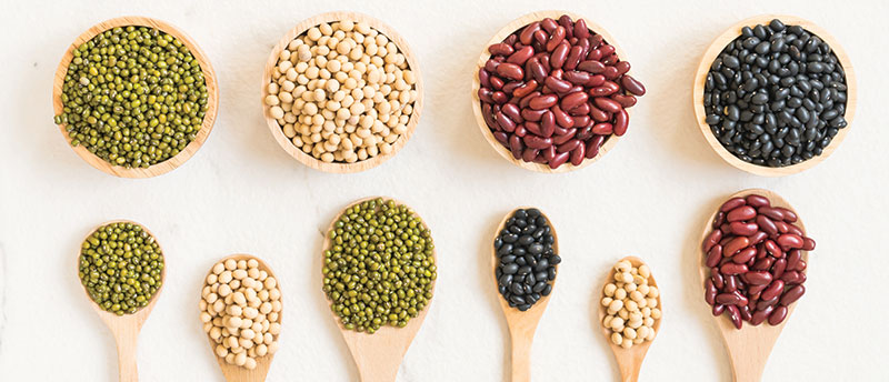 Mixed beans in wooden bowls and spoons