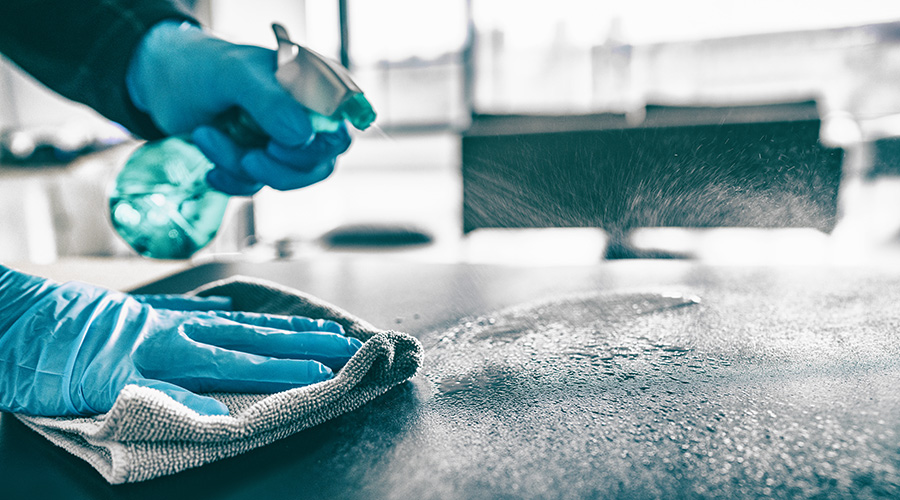 Cleaning home table sanitizing kitchen table surface with disinfectant