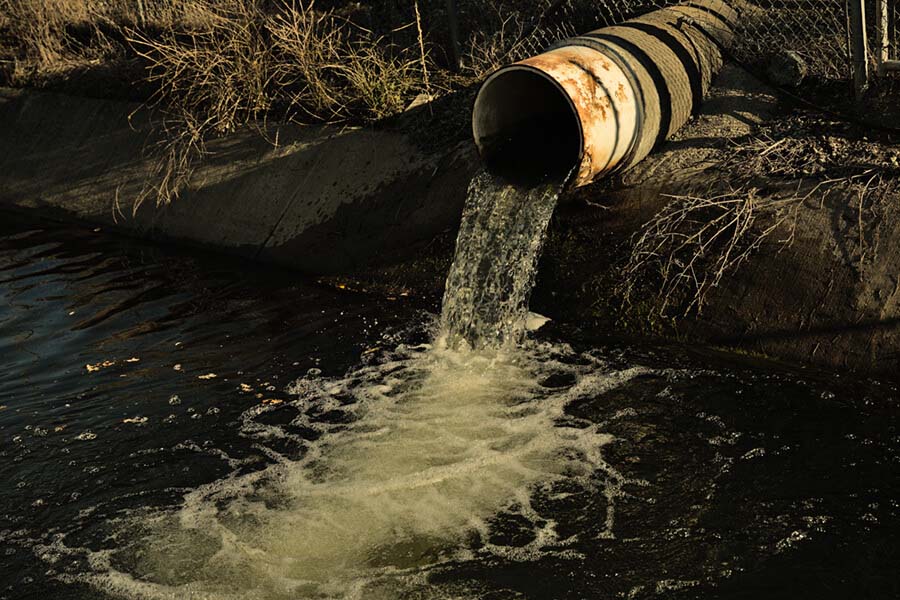 Dirt pipe releasing water into stream.