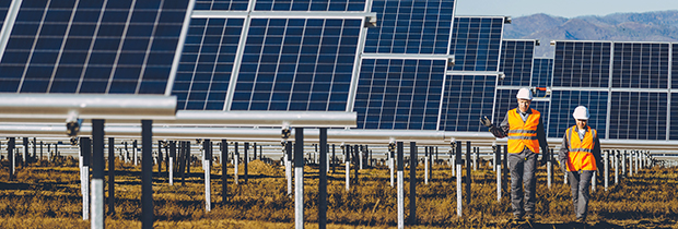 Solar power plant with two workers wearing safety helmets