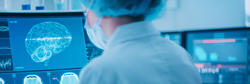 Scientist in laboratory reviewing brain scans